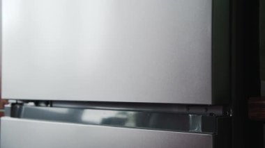 Kadın eli buzdolabının kapısını açar. Mutfakta rutin ev işleri..