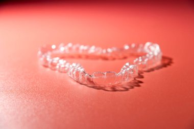 Görünmez ortodontik kozmetik dizilimli gradyan renk arkaplanı, diş hizalayıcıları, plastik diş telleri. Güzel bir gülümsemeye ve beyaz dişlere sahip olmanın yolu