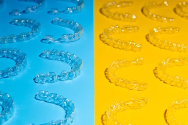 Görünmez ortodontik kozmetik diziliciler renkli bir arka planda, hizalayıcılar, plastik teller. Modern diş koruyucuları 3D yazıcıda oluşturuldu.
