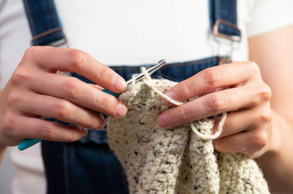 Руки женщины, делающей вязание, домашнюю работу. Одежда ручной работы, вечерние увлечения.