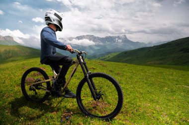 Bisikletli tanınmaz bir adam. Dağ bisikletçisi yaz orman manzarası boyunca at sürdükten sonra ayakta duruyor. Açık hava sporları.