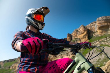 Bisikletli tanınmaz bir adam. Dağ bisikletçisi yaz aylarında dağ manzarasında at sürdükten sonra ayakta duruyor. Açık hava sporları.