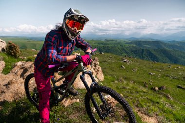 Bisikletli adam dışarıda bisiklette dinleniyor. Sporcunun portresi, miğfer takan ve gözlüklü adam gidona yaslanan kameraya bakıyor. Etkin eğlence konsepti mtb