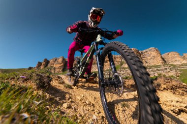 Kameraya doğru koşuyormuş gibi, vitesli ve korumalı bir bisikletçinin geniş açılı görüntüsü hızla alçalıyordu. Top sürme..