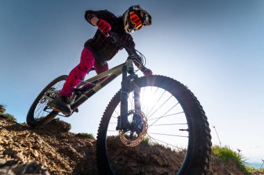 Dağ bisikletçisi çimenli bir yamaçtan aşağı iniyor. Enduro dağ bisikleti. Bir dağ manzarasına karşı MTB.