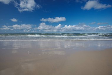 Güzel deniz manzarası, boş bir sahil, Baltık Denizi 'nin köpüklü suyu, beyaz bulutlu mavi gökyüzü. Slowinski Ulusal Parkı, Polonya.