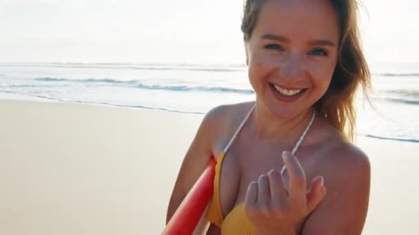 性感的冲浪手穿着比基尼的年轻而快乐的女人带着冲浪板在沙滩上散步 — 图库视频影像
