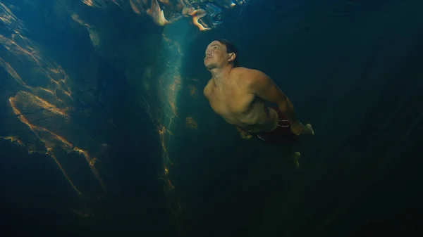 Mann Taucht Süßwasserfluss Mit Sonnenstrahlen Durch Das Wasser — Stockfoto