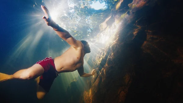 Man Dives Freshwater River Sunny Rays Shining Water Swims Rock — Stock Photo, Image