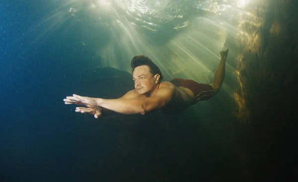 Człowiek Nurkuje Słodkowodnej Rzece Słonecznymi Promieniami Świecącymi Przez Wodę — Zdjęcie stockowe