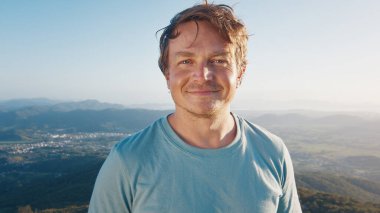 Gülümseyen genç adamın portresi. Güneş doğarken açık havada beyaz bir adam.