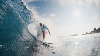 Sörfçü dalgada sörf yapar. Genç adam Maldivler 'de okyanus dalgalarında sörf yapar ve fıçıdan kurtulmaya çalışır.