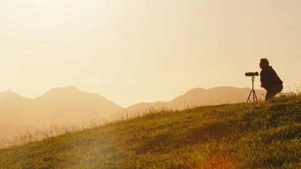 Tepedeki Fotoğrafçı Genç Erkek Fotoğrafçı Güneş Doğarken Dağların Yeşil Tepesindeki — Stok fotoğraf