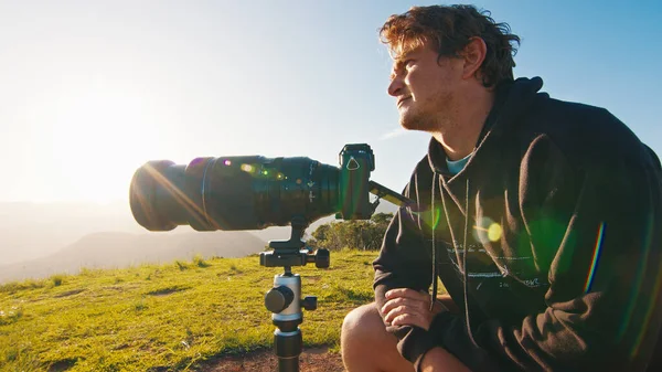 山上的摄影师 年轻的男性摄影师在日出时分 在青山上的三脚架上 用相机和心灵感应镜头拍照 — 图库照片