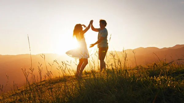男人和女人在夏日的草地上跳舞 在日出时分 草地上撒满了草 图库图片