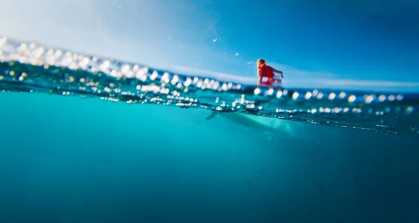 モルディブの黄色いロングボードの波をサーフィンする赤いスーツの女性サーファー — ストック写真