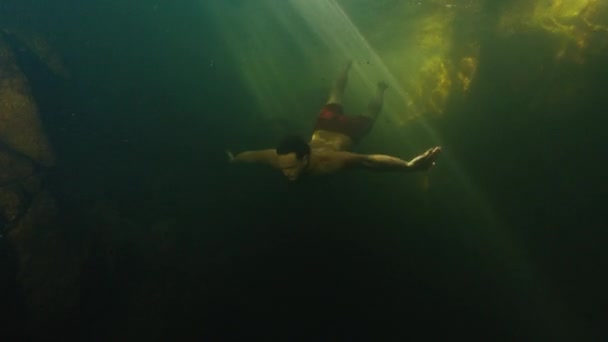 Man Dives Freshwater River Sunny Rays Shining Water Swims Rock — Stock Video