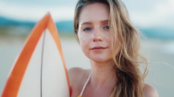 セクシーなサーファーだ 若い女性はビーチでサーフィンボードと立って カメラを見て — ストック動画