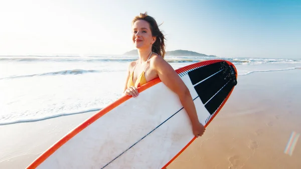 女冲浪手与冲浪板一起在热带海滩上散步 — 图库照片