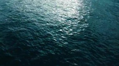 Deniz yüzeyi aşağı havadan görünüyor. Kamera su yüzeyinde dalgalar ve dalgalarla uçuyor.