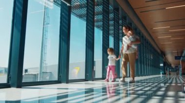 Ailesi havaalanında. Annesi ve iki çocuğu havaalanında yürüyor.