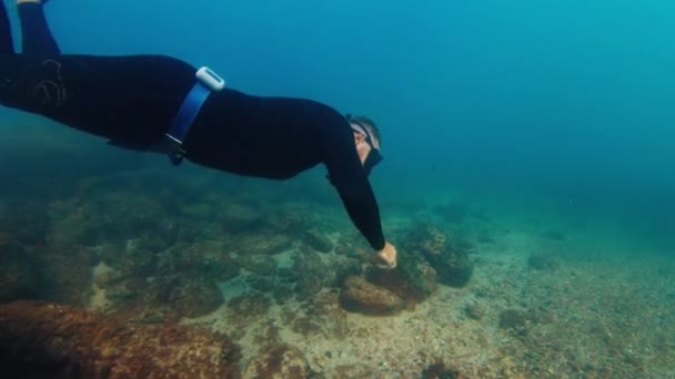 自由潜水员在黑暗的海里游泳 滑过岩石底部 在海里游泳的自由者 — 图库视频影像