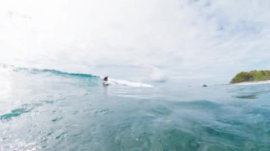 Dişi sörfçü Maldivler 'de sörf yapıyor.