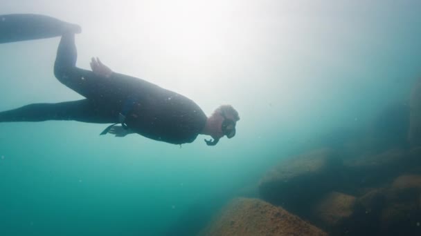 Free Diver Swims Underwater Murky Sea Glides Rocky Bottom Freediver — Stock Video