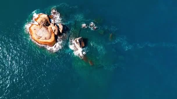 海の真ん中に浮かぶ岩礁の島の空中写真 — ストック動画