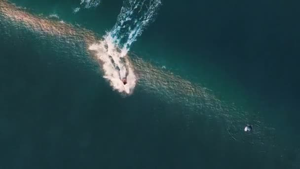 インドネシアのバリ島のバトゥ ボロン サーフィン スポットで波をサーフィンする女性 波に乗る女性サーファーの空中トップダウンビュー — ストック動画