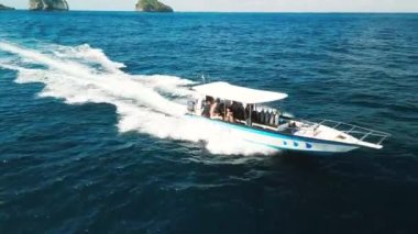 NUSA PENIDA, BALI, INDONEZYA - 12 Temmuz 2023: Nusa Penida adası kıyılarına doğru dalan dalgıçların sürat teknesinin hava izleme görüntüleri