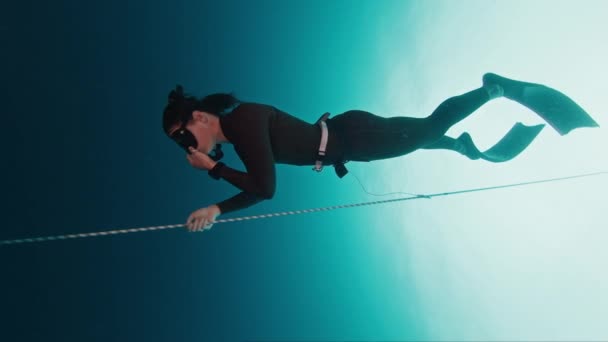 自由者在绳子上工作 妇女自由潜水者在开阔的海面上沿着绳子进行训练 然后下潜到水深处 自由自在地投入训练 — 图库视频影像