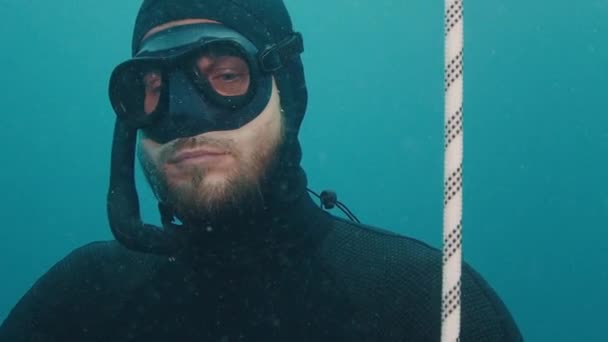 바다에서 다이빙 작업하는 밧줄을 올라가는 편안한 프리다이버의 초상화 — 비디오
