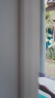 Genç adam bahçede esneme egzersizi yapıyor.