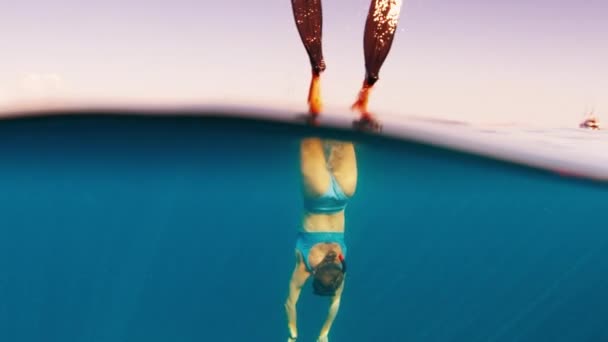 女性はアヒルをダイビングし 日没と降下で海で水中を泳ぎます — ストック動画