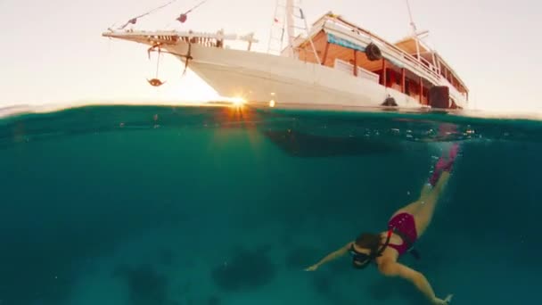 Női Szabadúszó Víz Alatt Úszik Öbölben Horgonyzó Mentőcsónak Közelében Napnyugtakor — Stock videók