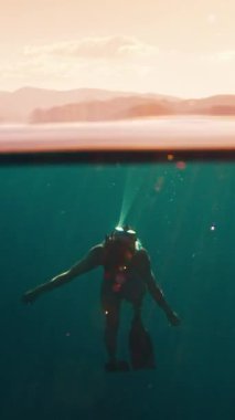 Freediver 'ın sineması. Kadın serbest dalgıç yüzeyin altında yüzer. Suyun altına dalan modelin kusursuz bir şekilde çevrilebilir görüntüleri.