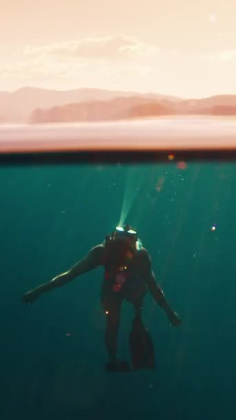 解放者のシネマグラフ 女性の自由ダイバーは地表の下に浮かぶ モデルの水中ダイビングのシームレスなループ可能な映像 — ストック動画