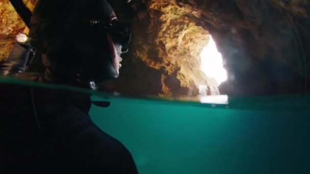 水で満たされた洞窟で飛ぶコウモリを見るウェットスーツのフリーダイバー — ストック動画