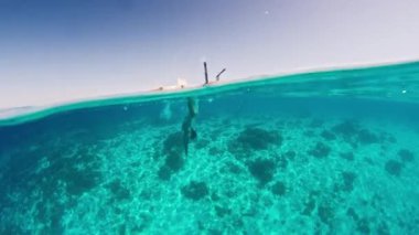 Ördek dalışı serbest. Kadın ördek dalışı yapıyor ve serbest dalış yapıyor.