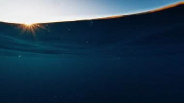 Sualtı, günbatımında Endonezya 'daki Komodo Ulusal Parkı' ndaki sakin deniz ve ünlü Komodo adasını ikiye böldü.