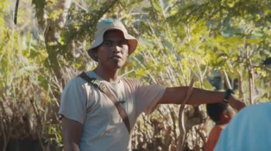 KOMODO ISLAND, 30 Temmuz 2023: Yerel rehber turistlerle konuşuyor ve ejderhalarla ünlü Komodo Ulusal Parkı 'nı ziyaret etmeden önce bu kuralları açıklıyor