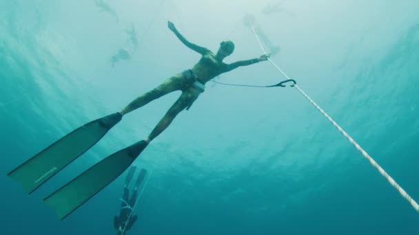 在海里用绳子挣脱 女自由选手在热身跳水过程中悬吊在绳索上 训练静息屏住呼吸 — 图库视频影像