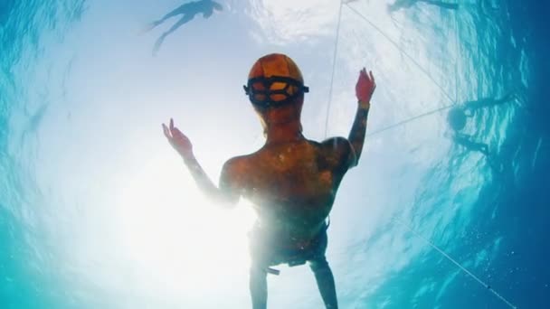 Женщина Фридайвер Надувает Кольцевые Пузыри Водой Команда Фридайверов Плавает Поверхности — стоковое видео