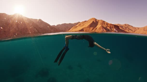 日出时在平静的热带海中游泳的男人的照片 海面冻结框架和水下运动模型 — 图库视频影像