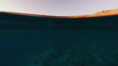 Sualtı, günbatımında Endonezya 'daki Komodo Ulusal Parkı' ndaki sakin deniz ve ünlü Komodo adasını ikiye böldü.