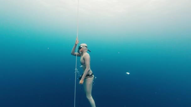 在海上免费潜水训练中 自信的女自由选手紧闭双眼沿着绳子爬升 — 图库视频影像