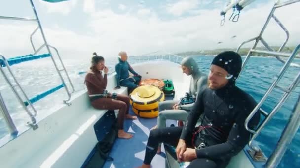 スプラッシュで荒い海に移動するボートに座っているウェットスーツの解放された川のグループ — ストック動画