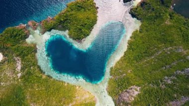 Endonezya, Raja Ampat 'ta kalp şeklinde bir göl. Papua 'daki aşk gölü, kireçtaşı dağlarının ve kalp şeklindeki gölün havadan görünüşü. Misool, Endonezya