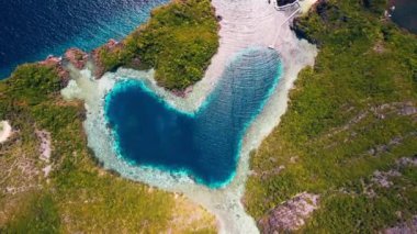 Endonezya, Raja Ampat 'ta kalp şeklinde bir göl. Papua 'daki aşk gölü, kireçtaşı dağlarının ve kalp şeklindeki gölün havadan görünüşü. Misool, Endonezya